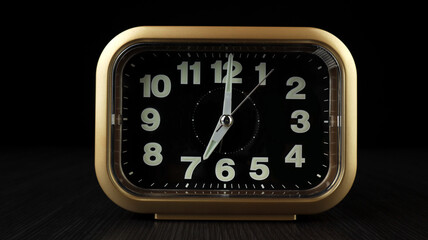 analog table clock alarm to help wake up in the morning. Analog clock on black background