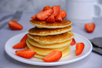 Pancakes with strawberries on a blurred background. Food photography.