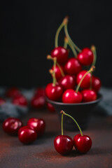 Composition of sweet cherries on a dark background with water drops top view