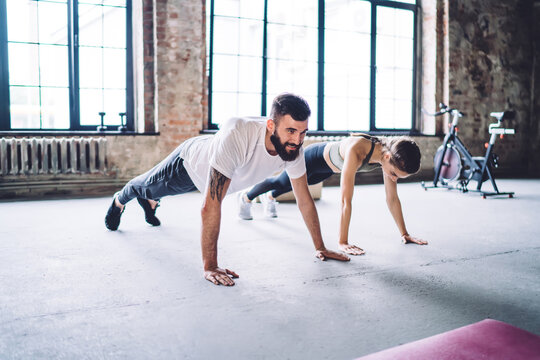 Strong male and female in active wear training together standing in plank endurance training strength, couple in love enjoying active sporty workout reaching fitness goals and making perfect figure © BullRun