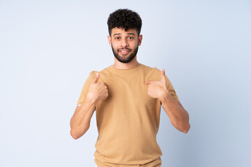 Young Moroccan man isolated on blue background with surprise facial expression