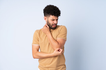 Young Moroccan man isolated on blue background with pain in elbow