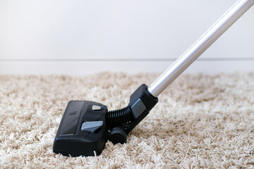 cordless vacuum cleaner is used to clean the carpet in the room. Housework with a new handheld...