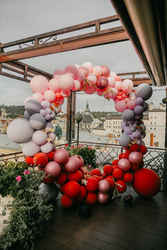 Front view of colorful balloons photozone in the restaurant on the old city background.