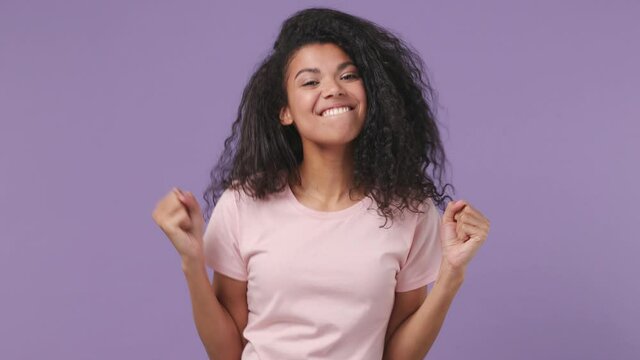 Young african woman 20s years old wears pink T-shirt countdown 1 2 3 one two three go celebrate win scream rejoices doing winner hands gesture isolated on pastel violet purple color background studio