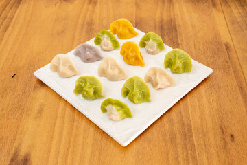 Cooked Chinese dumplings of different flavors on white plate