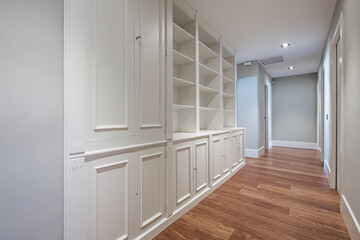 Custom made lacquered wood bookcase in home corridor