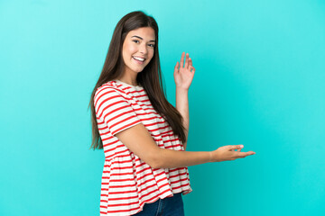 Fototapeta premium Young Brazilian woman isolated on blue background extending hands to the side for inviting to come