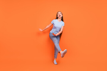 Fototapeta na wymiar Full body photo of young cheerful girl happy positive smile have fun excited dance party isolated over orange color background