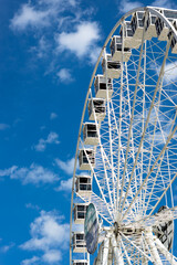 Ferris wheel in a sunny day with white clouds