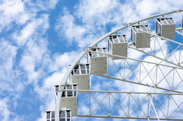Ferris wheel in a sunny day with white clouds