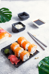 Philadelphia sushi roll made of fresh salmon, avocado and cream cheese inside. Traditional Japanese cuisine. Asian food