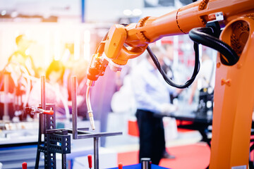 Process robot hand performs welding work on metal structures industrial automatic factory, light...