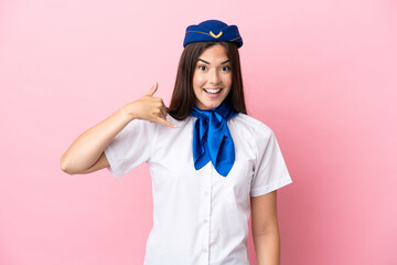 Airplane stewardess Brazilian woman isolated on pink background making phone gesture. Call me back sign