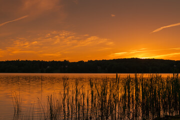 A low angle photograph of an early summer sunset from across the lake.