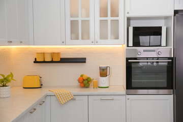 Light kitchen interior with stylish furniture and modern equipment