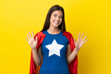 Super Hero Brazilian woman isolated on yellow background counting ten with fingers