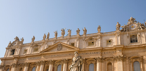 Obraz premium Vatican city. Details of the upper sector of St Peter´s Basilica. At front, the statue of Saint Paul.