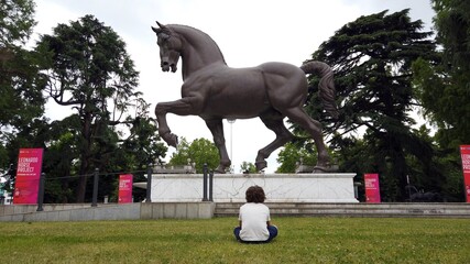 Europe, Italy , Milan June 2021 - Leonardo Da Vinci  horse statue and boy 6 years old visiting the...