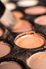 eye shadow is close. A makeup brush with eye shadow on it scatters the grains. macro palettes with shadows