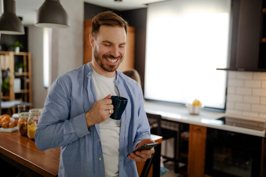 Handsome smiling man enjoying time for internet and coffee. - Powered by Adobe