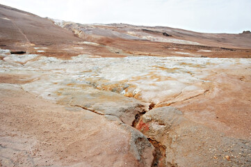 Hverir geothermal area in North of Iceland, volcano mud pots and cracked red ground