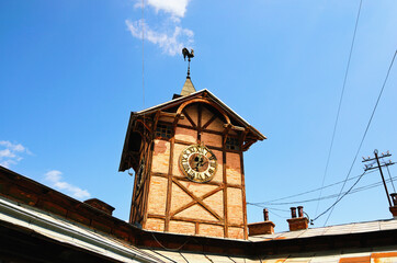 Scenic landscape view of ancient wooden townhall with vintage clock against cloudy sky. Chortkiv, Ukraine