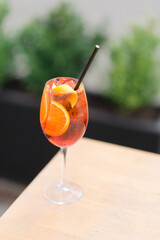 Orange cocktail on a table on the street. Orange cocktail with a slice of orange.