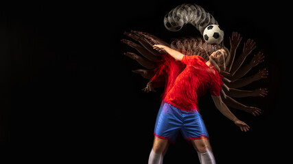 Non stop moving. Young caucasian football soccer player playing in motion in mixed light on dark...