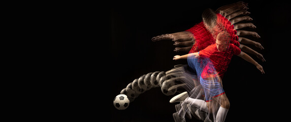 Non stop moving. Young caucasian football soccer player playing in motion in mixed light on dark background.