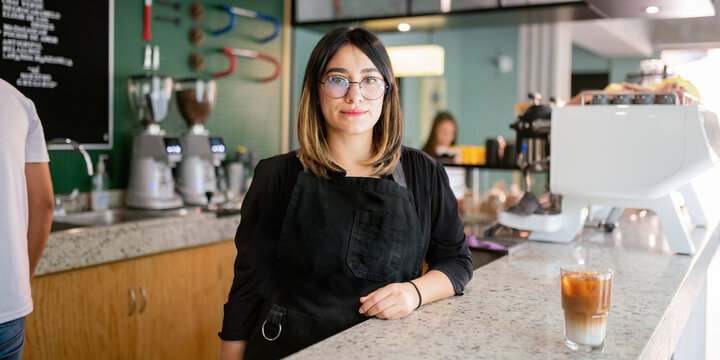Female coffee shop owner standing at counter