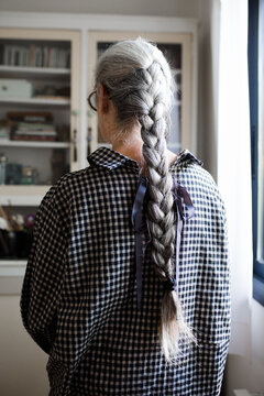 Senior woman with a long braid looking out the window
