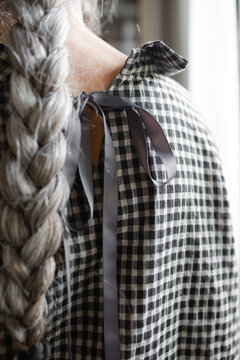 Senior woman white a long braid looking out the window
