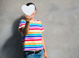 Woman in a multi-colored T-shirt LGBT holding heart icon  symbol of the LGBT Human Rights, Equality, LGBT
