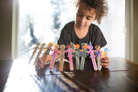 Child shows off decorated popsicle stick dancers