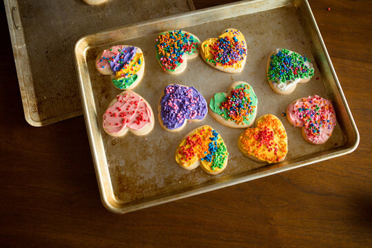 Brightly decorated Valentines Day cookies on baking sheet