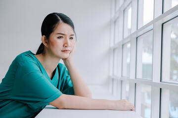 A beautiful nurse sits in a chair with a gloomy and anxious expression, nursing the concept with trust and care.