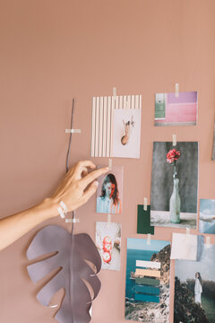 Young Woman's Hand Hanging Photo on the Wall for Moodboard