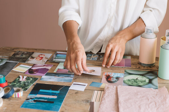 Young Woman's Hands Selecting Pictures for a Moodboard