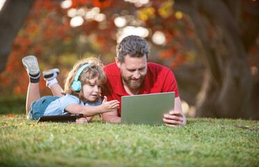 happy family of father and son use laptop for video call in park, family day.