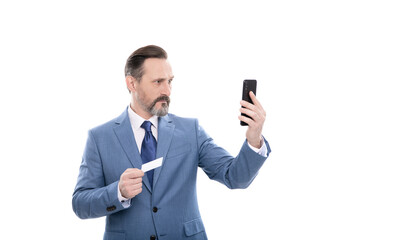 Naklejka premium serious mature boss in suit hold credit card and phone isolated on white, selfie