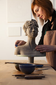 artist finishing a clay statue