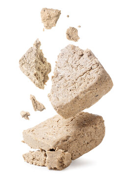 Halva broken into pieces falls on a white background.