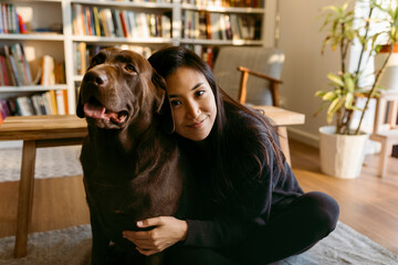 cute labrador dog and her owner sitting on floor at home