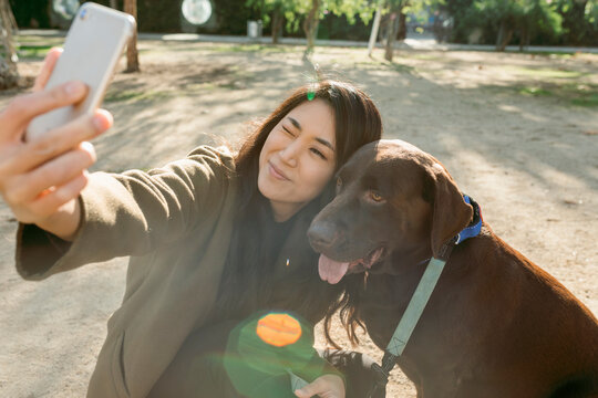 asian woman and her labrador dog taking a selfie