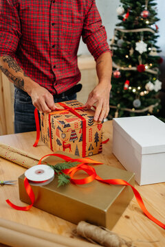 Unrecognizable man wrapping christmas presents