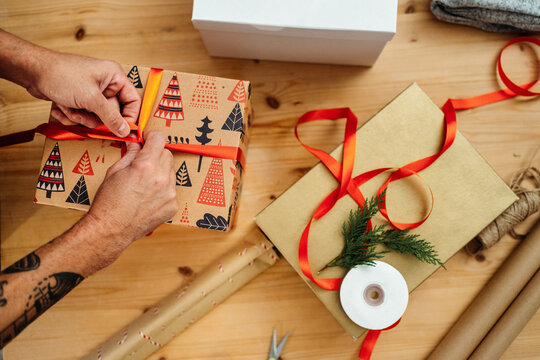 Unrecognizable man wrapping christmas presents