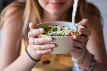 Young woman smiling holding take out food container