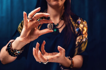 Astrology and horoscope. A woman holds a stone with the sign of the zodiac leo. Close up. The concept of divination and magic