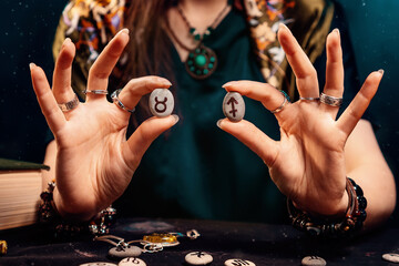 Astrology and horoscope. Female's holds stones with the zodiac sign of Taurus and Sagittarius. The...